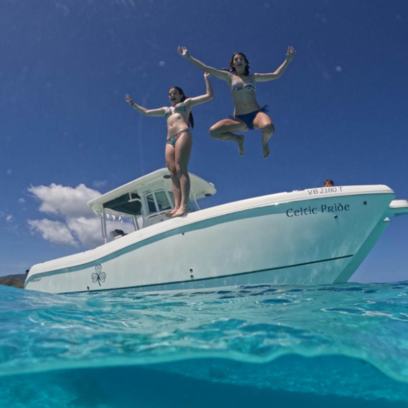 Kids jumping off Celtic Wisdom Powerboat into the crystal clear waters of the Virgin Islands and swimming in the BVI.